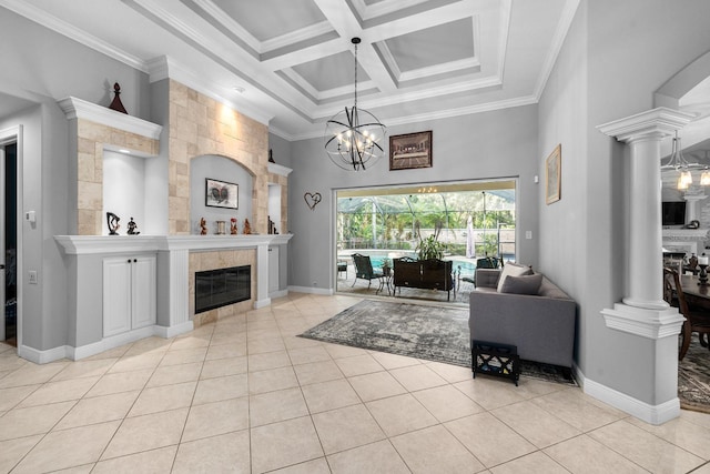 living room with light tile patterned flooring, a tiled fireplace, a high ceiling, ornamental molding, and an inviting chandelier