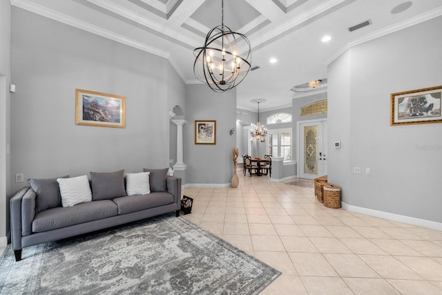 living area with light tile patterned flooring, crown molding, coffered ceiling, and a notable chandelier
