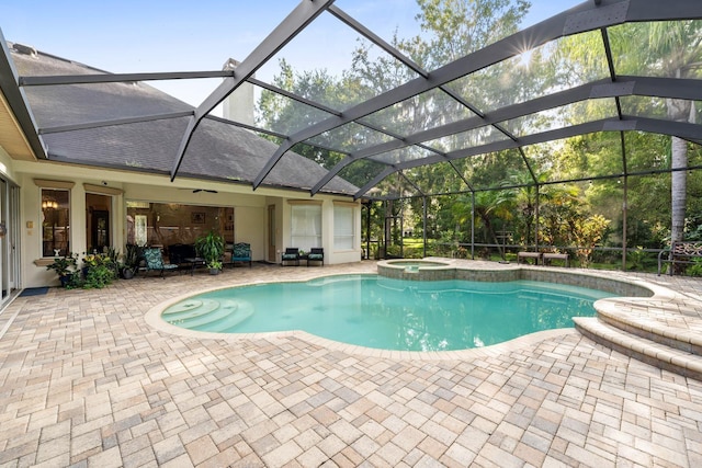 view of pool featuring a patio, a pool with connected hot tub, and glass enclosure