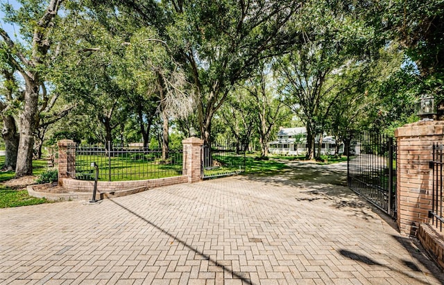 view of gate with a fenced front yard and a lawn