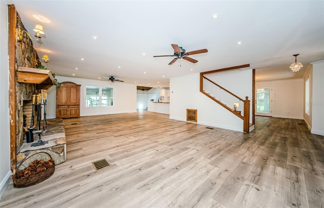 unfurnished living room featuring ceiling fan and light hardwood / wood-style floors