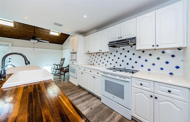 kitchen featuring lofted ceiling, white cabinetry, sink, and white appliances