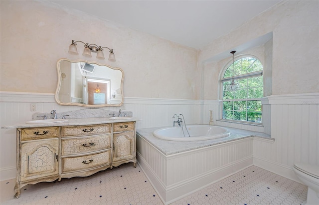 bathroom with a washtub, tile patterned flooring, vanity, and toilet