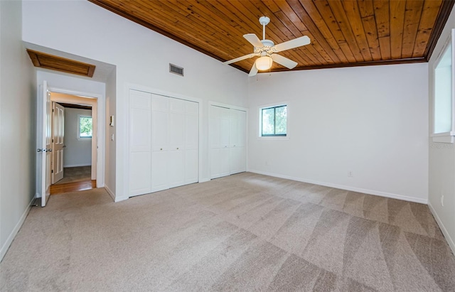 unfurnished bedroom featuring ceiling fan, wooden ceiling, vaulted ceiling, multiple windows, and light carpet