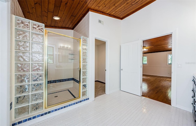 bathroom with ceiling fan, wood ceiling, and tiled shower