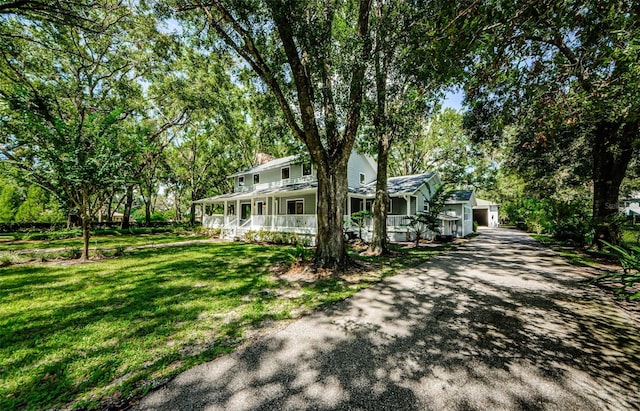 exterior space with a front lawn, covered porch, and a chimney