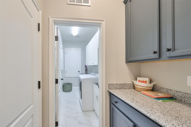 laundry area featuring washer and dryer and cabinets