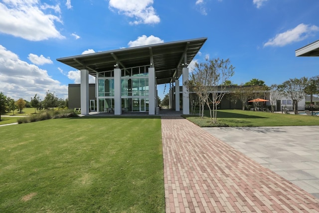 rear view of property with a carport and a yard