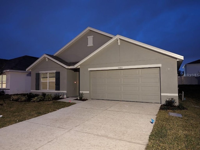 single story home featuring a front lawn and a garage