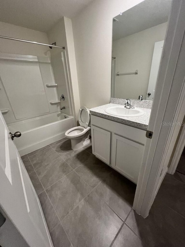 full bathroom with washtub / shower combination, tile patterned flooring, vanity, and toilet