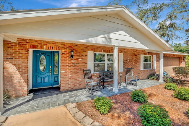 doorway to property with a porch and a garage