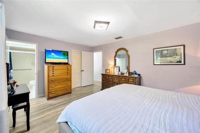 bedroom featuring light hardwood / wood-style flooring and connected bathroom