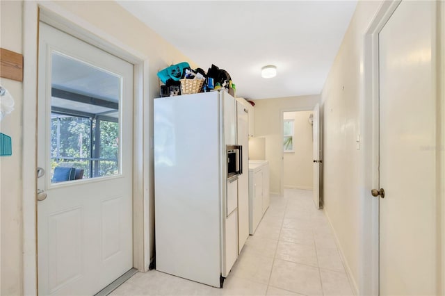 kitchen with white fridge with ice dispenser, light tile patterned floors, and white cabinets