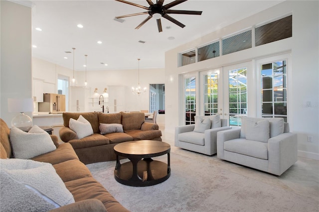 living room with recessed lighting, french doors, a high ceiling, and ceiling fan with notable chandelier