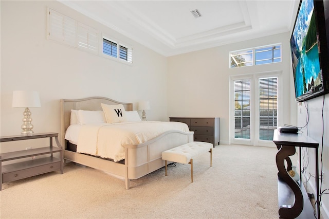 carpeted bedroom featuring access to outside, visible vents, and a raised ceiling