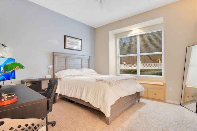 bedroom with baseboards and light colored carpet