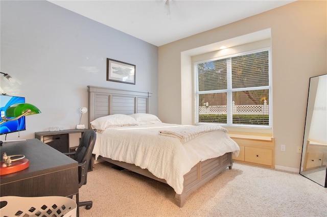 bedroom with light colored carpet and baseboards