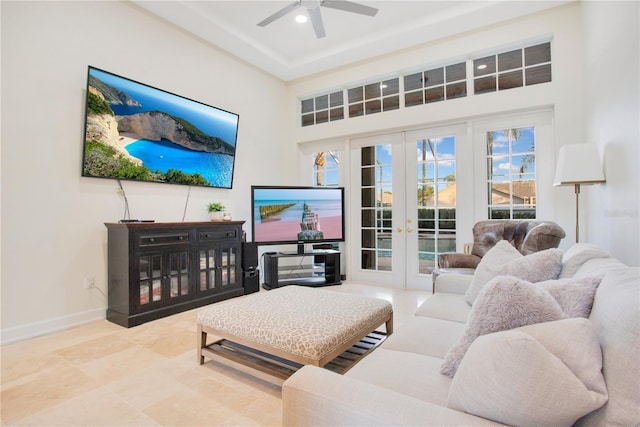 living area featuring french doors, a towering ceiling, baseboards, and ceiling fan