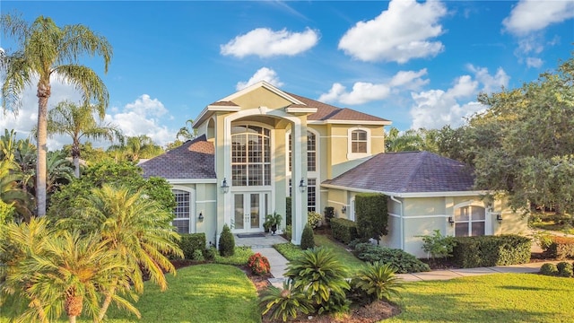 view of front of house featuring french doors, a front yard, and stucco siding