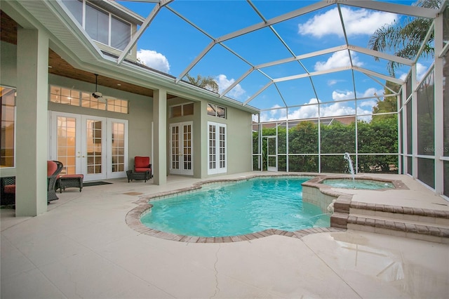 view of pool with a pool with connected hot tub, a lanai, french doors, a patio area, and a ceiling fan