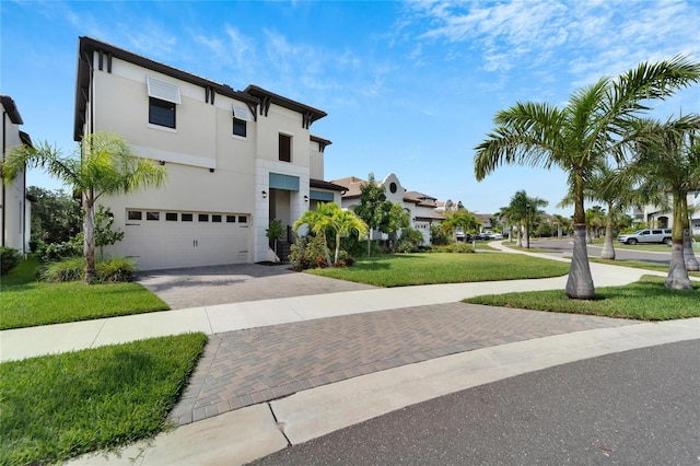 view of front of home with a front yard and a garage