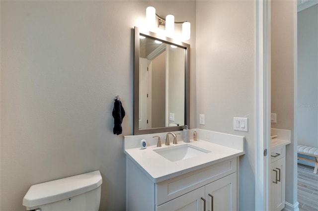 bathroom featuring wood-type flooring, vanity, and toilet