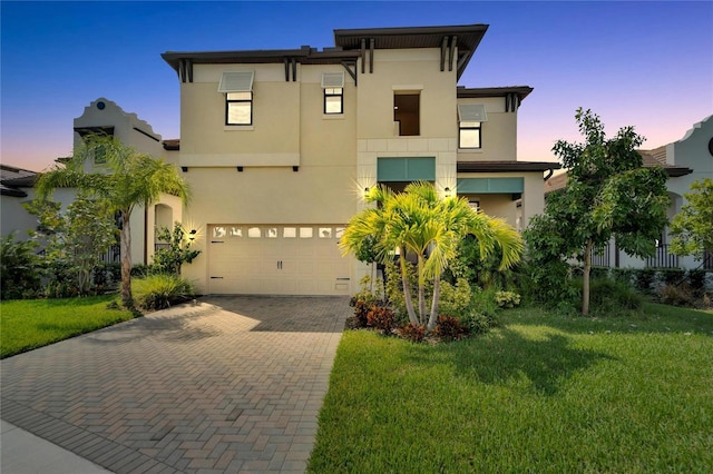 view of front of property featuring a garage and a yard