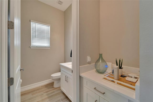 bathroom with hardwood / wood-style flooring, vanity, and toilet