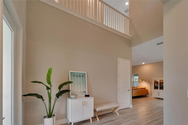 interior space featuring a towering ceiling and hardwood / wood-style flooring