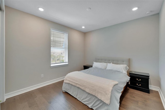 bedroom with dark hardwood / wood-style floors