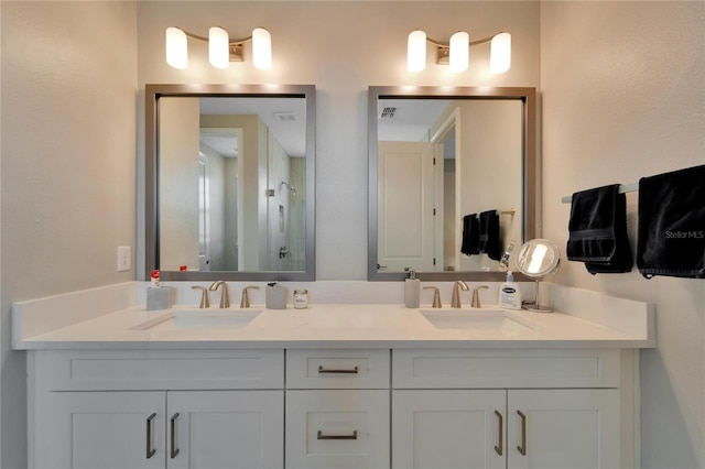 bathroom with a shower with shower door and vanity