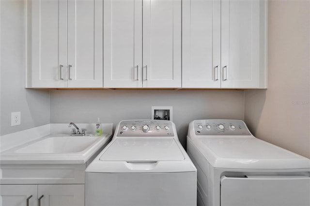 laundry room with sink, washer and dryer, and cabinets