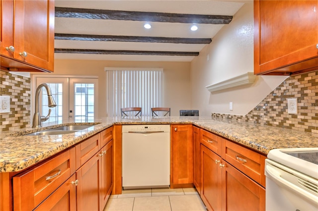 kitchen featuring white dishwasher, light stone counters, kitchen peninsula, and sink