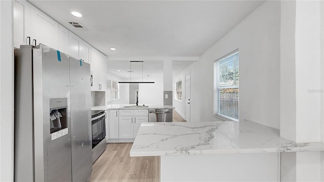 kitchen with stainless steel appliances, white cabinetry, and kitchen peninsula