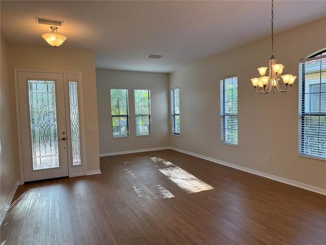 entrance foyer with dark wood-type flooring and a notable chandelier