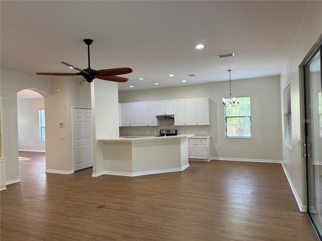 kitchen featuring white cabinets, decorative backsplash, decorative light fixtures, and dark hardwood / wood-style floors