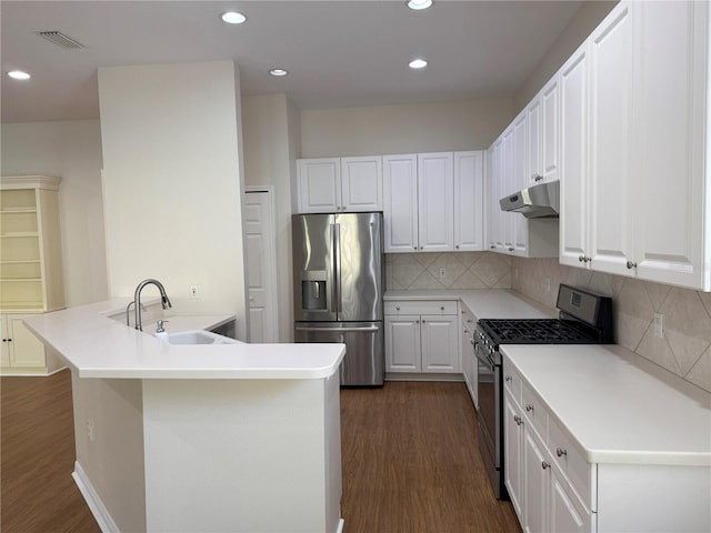 kitchen featuring sink, stainless steel appliances, dark hardwood / wood-style flooring, backsplash, and white cabinets