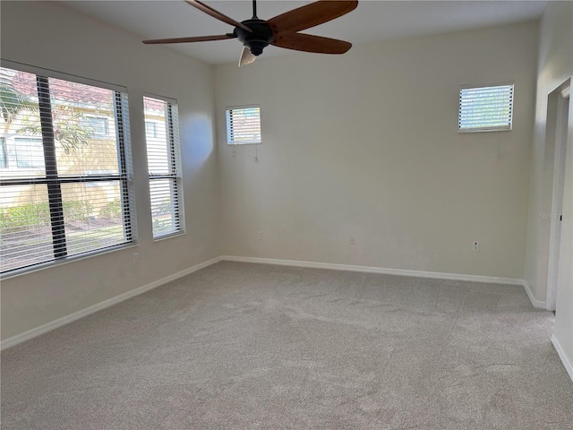 carpeted spare room featuring ceiling fan