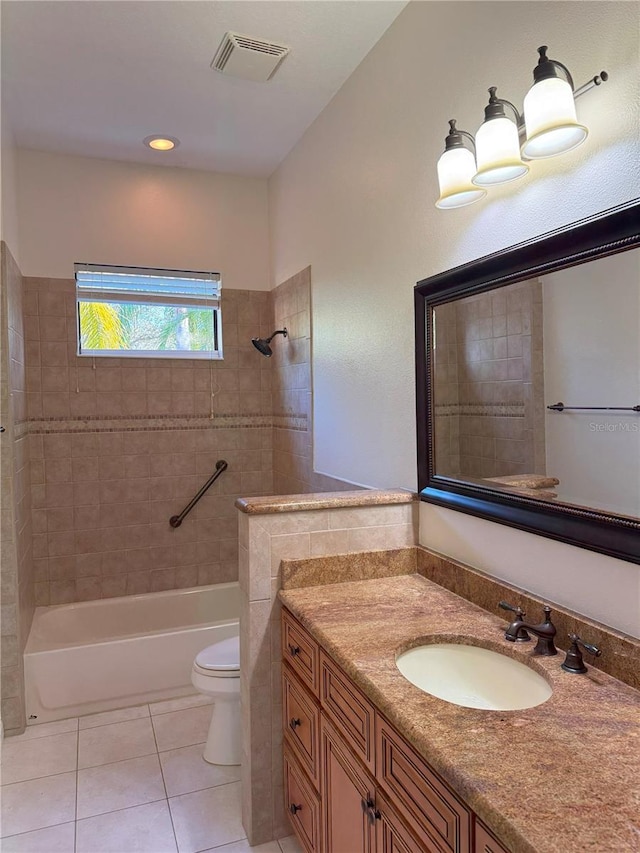 full bathroom featuring tiled shower / bath, tile patterned flooring, vanity, and toilet