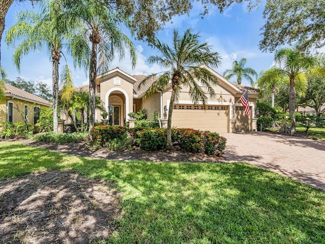 mediterranean / spanish-style home with a front lawn and a garage