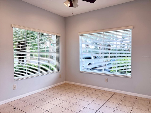 tiled spare room with a wealth of natural light and ceiling fan