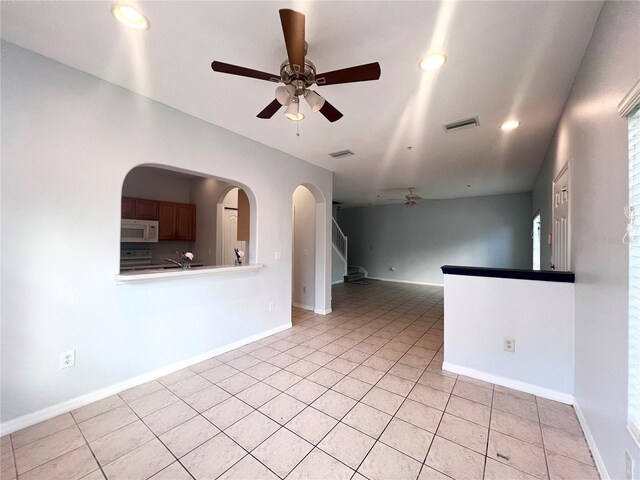 tiled empty room with ceiling fan