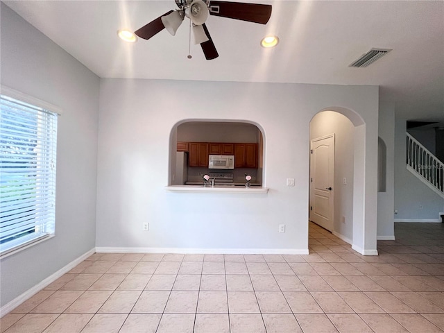 unfurnished room with ceiling fan and light tile patterned floors