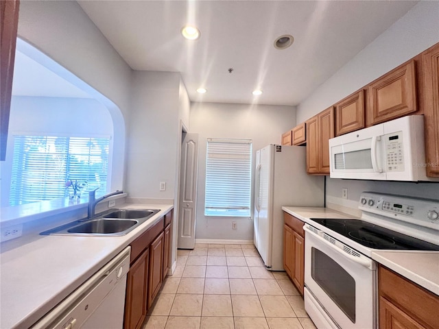 kitchen with light tile patterned floors, sink, and white appliances