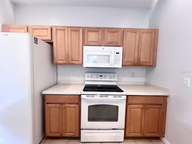 kitchen featuring light tile patterned floors and white appliances