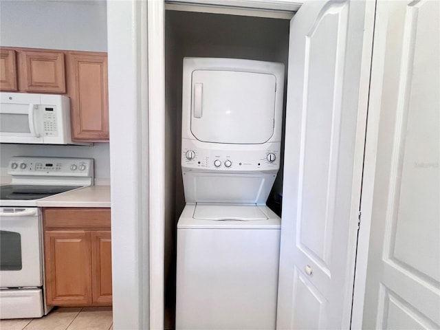 washroom featuring light tile patterned flooring and stacked washing maching and dryer