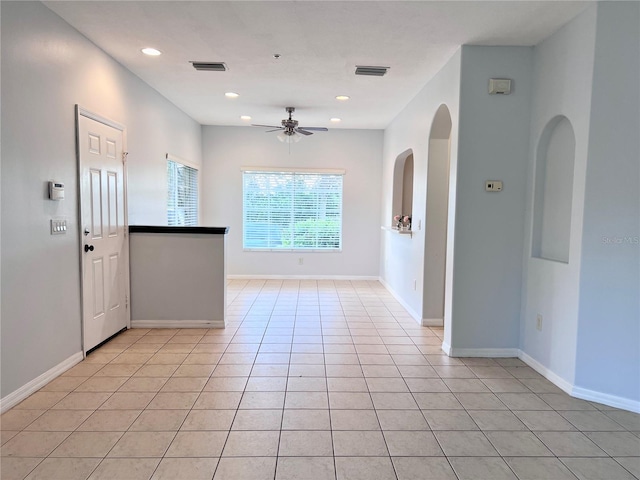 tiled spare room featuring ceiling fan