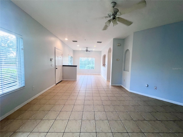 tiled spare room with ceiling fan