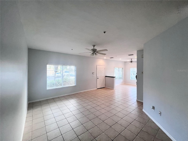 tiled empty room featuring ceiling fan, plenty of natural light, and a textured ceiling