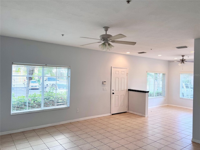 tiled empty room featuring a healthy amount of sunlight and ceiling fan